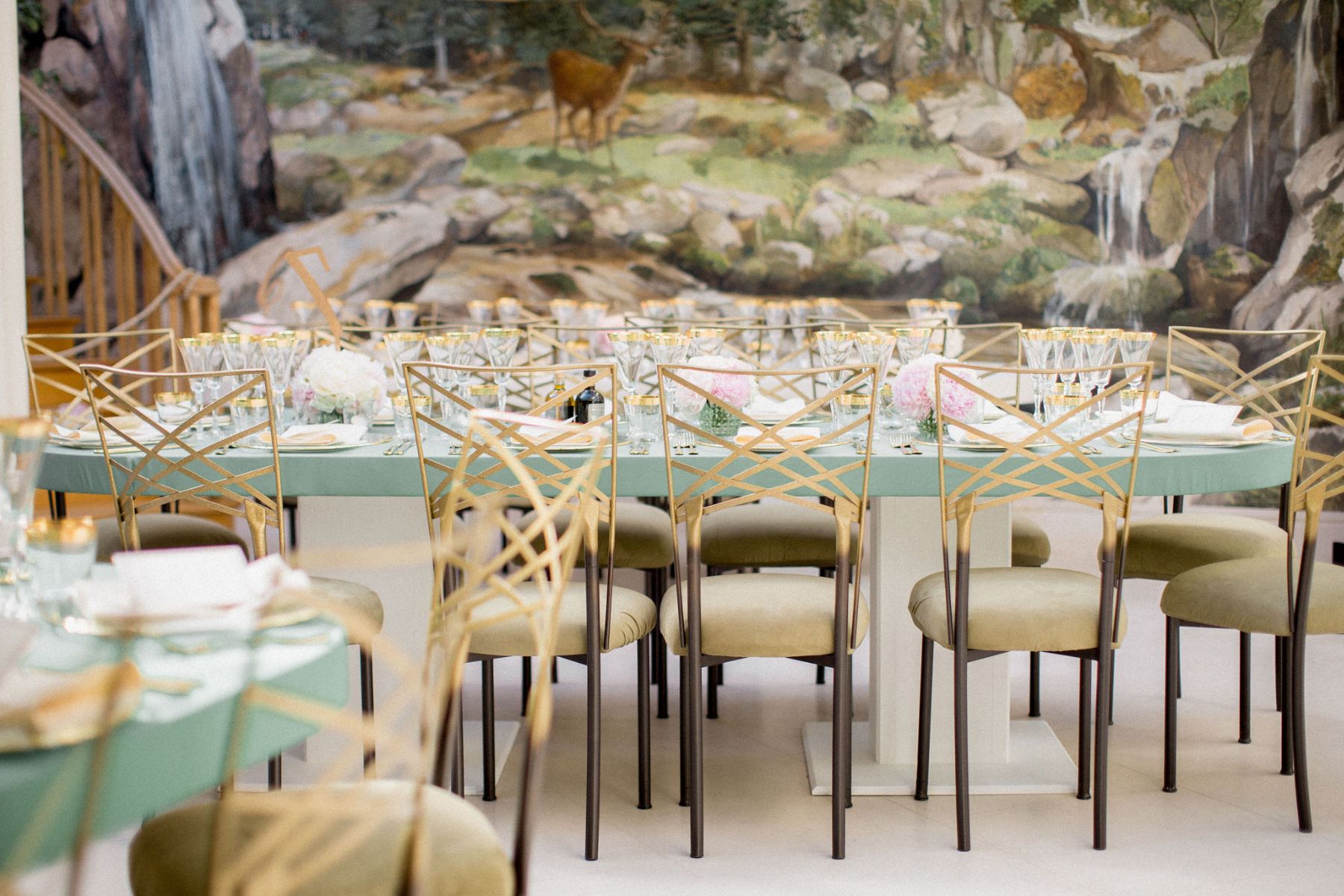 Reception and table-settings in front of ornate mural.
