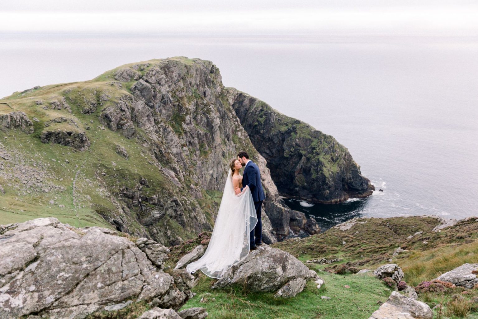 Bride and Groom embracing overlooking the sea.